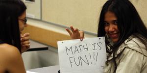 A student holds up a math is fun sign.