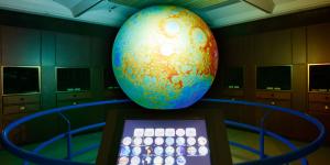 An interactive large light up globe sits in a dark room.
