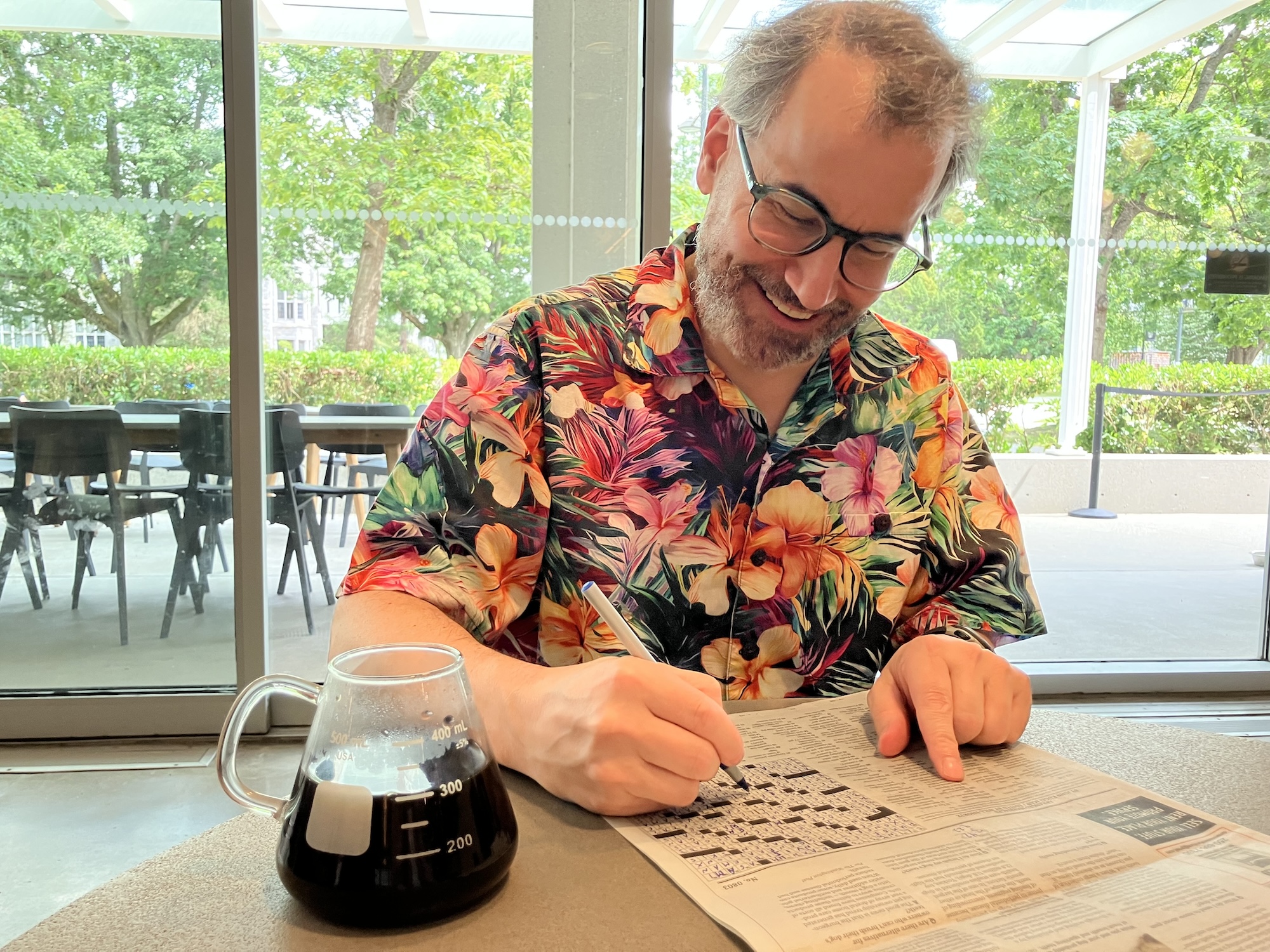Dr. Mark MacLachlan solves a crossword puzzle in a newspaper