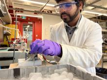 A researchers adjusts a CO2 electrolyzer powered by thermoelectric generators in a lab.