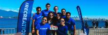 A group of students posed in front of the Vancouver skyline at Waterfront.