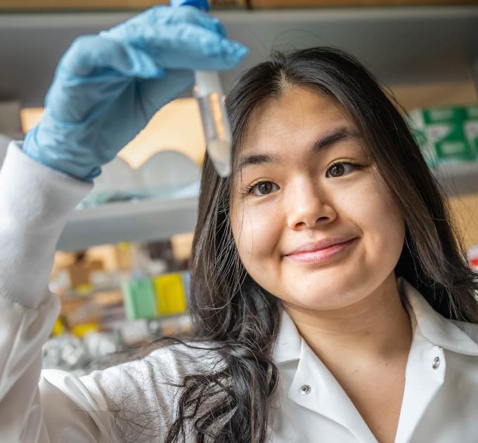 A student holds up a test tube in a lab.